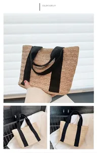 Detail view of beige straw tote bag featuring black woven handles and herringbone texture