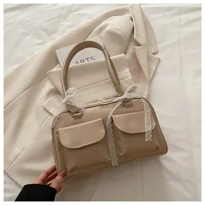 Détail du sac oreiller crème élégant avec nœuds en dentelle et poches à rabat symétriques