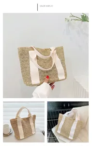 Detail of hand-woven straw tote bag featuring white canvas handles and herringbone pattern