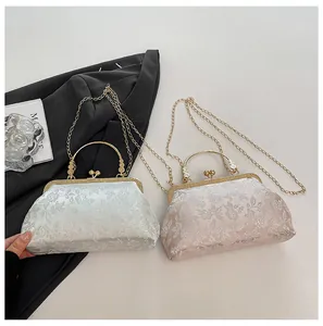 Detail of vintage floral brocade clutch bags with heart-shaped metal kiss-lock closures