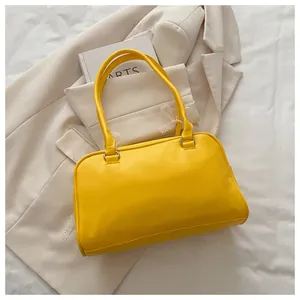 Détail d'un sac à main en cuir jaune vif avec anneaux argentés et dentelle