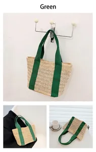 Detail view of woven straw beach bag featuring green canvas handles and herringbone pattern