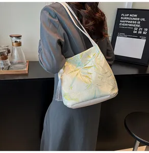 Detailed view of bamboo leaf jacquard fabric on a tote bag with grey fringe tassel charm