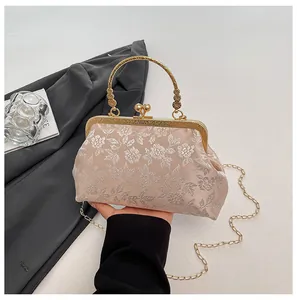 Détail du tissu brocart floral champagne avec poignée dorée vintage et fermoir à baisers