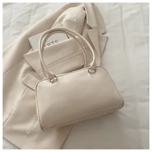 Détail d'un sac oreiller crème avec dentelle, cuir PU souple et poignées cylindriques