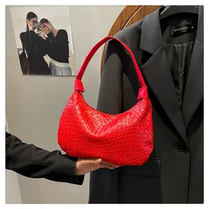 Detailed close-up of vibrant red woven hobo bag with textured faux leather finish