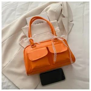 Détail du sac à main en cuir PU orange vif avec des nœuds en dentelle et doubles poches