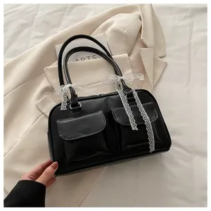 Détail du sac en cuir PU noir avec nœuds en dentelle blanche et poches avant symétriques