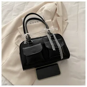 Détail d'un sac à main en cuir noir avec nœuds en dentelle blanche et poches avant