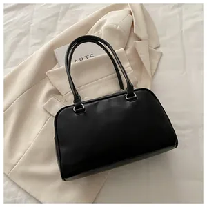 Vue de dessus d'un sac bandoulière en cuir noir avec anneaux métalliques argentés