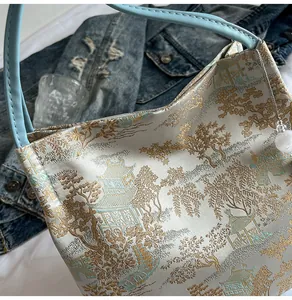 Detail of blue jacquard handbag with traditional Chinese landscape embroidery and bead