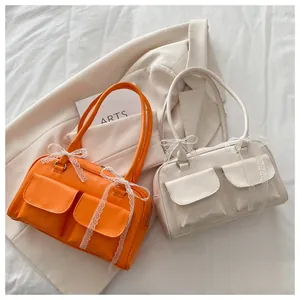 Détail du sac oreiller de style vintage avec nœuds en dentelle et deux poches avant