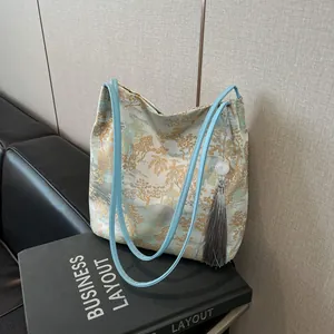 Blue jacquard tote bag with traditional Chinese landscape patterns and tassel detail