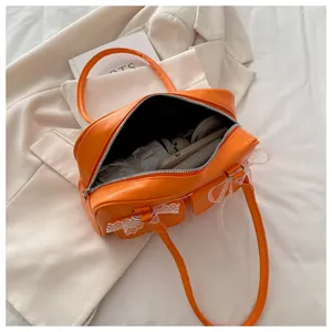 Vue de dessus du sac orange à dentelle montrant l'intérieur spacieux avec des objets