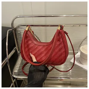 Dettaglio della borsa hobo intrecciata rossa con texture e finiture dorate