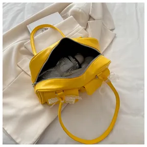 Gros plan du sac oreiller jaune montrant l'intérieur spacieux et le nœud en dentelle