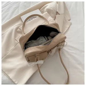 Détail intérieur du sac à bandoulière beige à nœud dentelle montrant sa grande capacité