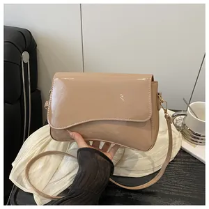 Detail of glossy beige PU leather shoulder bag featuring sleek texture and golden hardware