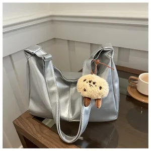 Grand sac fourre-tout argenté métallisé avec charm mouton en peluche sur table bois