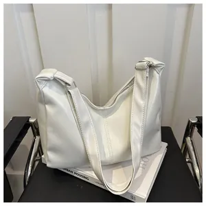 Détail de la texture en cuir PU blanc souple et de la fermeture éclair argentée du sac