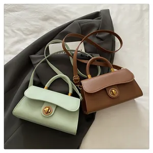 Detail view of mint green and brown PU leather crossbody bags with gold rotary clasps
