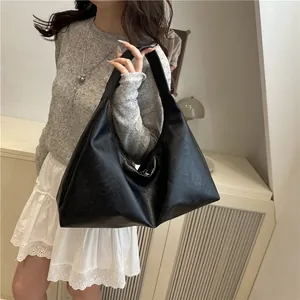 Minimalist black faux leather tote bag with retro pleated texture and wide shoulder strap