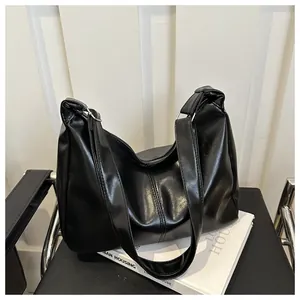 Détail du sac hobo en similicuir noir avec anneau métallique et surpiqûres