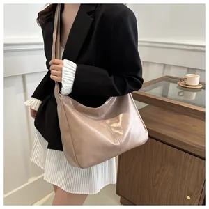 Grand sac cabas élégant couleur abricot porté à l'épaule par un mannequin en intérieur