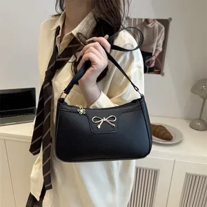 Chic black litchi leather underarm bag with metal bow and flower charm for daily use