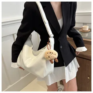Sac bandoulière chic blanc cassé brillant avec un charme en peluche marron