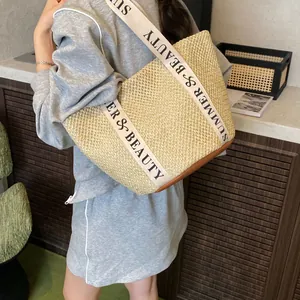 Large straw tote bag with Summer & Beauty straps and brown leather base shown on model