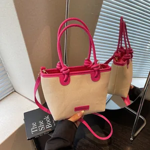 Sac seau bicolore chic avec poignée nouée et finitions en cuir rose en studio photo