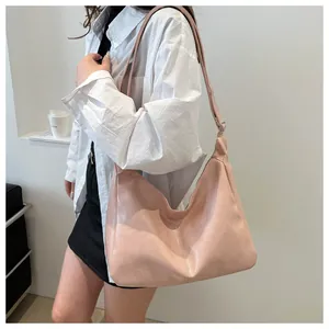 Gros plan d'un grand sac fourre-tout rose pâle en similicuir avec bandoulière