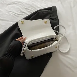 Minimalist white glossy patent leather shoulder bag with gold clasp and sleek design