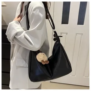 Détail du sac hobo noir avec bandoulière réglable et pendentif poussin en peluche