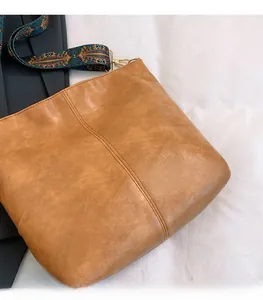 Detail of brown faux leather tote with vintage ethnic style printed wide shoulder strap