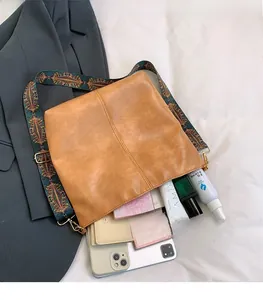 Spacious interior of brown faux leather tote bag with embroidered ethnic strap