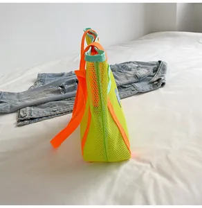 Detail view of neon mesh tote bag showing the side depth and vibrant orange shoulder strap
