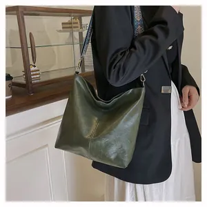 Detail of dark green tote bag with wide ethnic embroidery shoulder strap in cafe setting