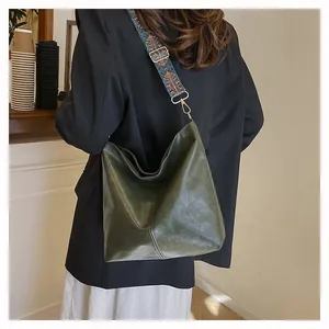 Dark green hobo shoulder bag featuring a decorative geometric patterned wide strap