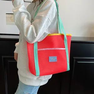 Vibrant red mesh tote bag with green handles for beach, swimming and grocery shopping