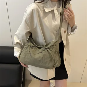 Army green large tote bag with ribbon bow and drawstring detail for daily commute