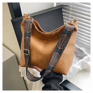 Detail of caramel tote bag featuring textured PU leather and bohemian geometric strap