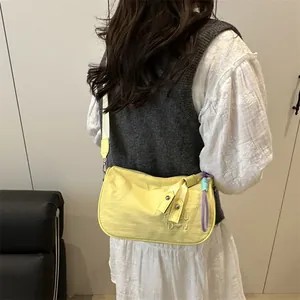 Fashionable yellow nylon underarm bag with letter embroidery and colorful pendant charm