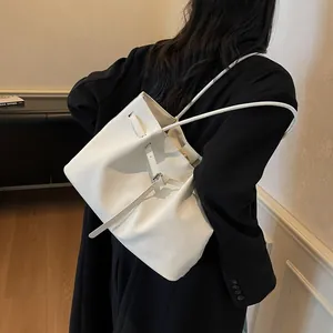 Minimalist white woven tote bag shown on model with sleek shoulder strap and textured finish