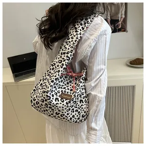 Detail of leopard print tote bag with pink plaid ribbon and fashion leather label