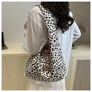 Detail of hobo bag featuring black and white leopard print and fashion label