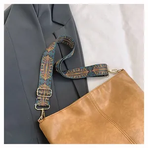 Detail of camel tote bag featuring a colorful ethnic pattern wide woven shoulder strap