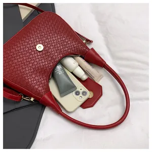 Interior view of red woven shoulder bag showing storage capacity for phone and cosmetics