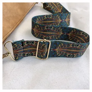 Detail of adjustable woven strap with vintage geometric patterns and gold metal hooks